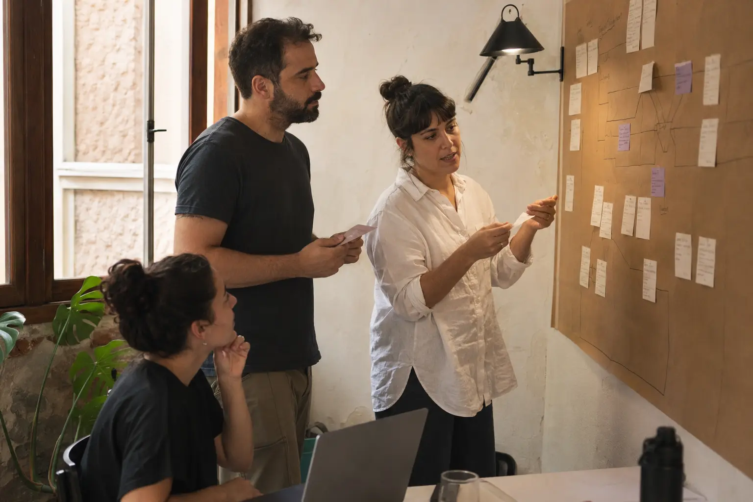 Equipe reunida em um workshop de criação, com papéis e protótipos sobre a mesa